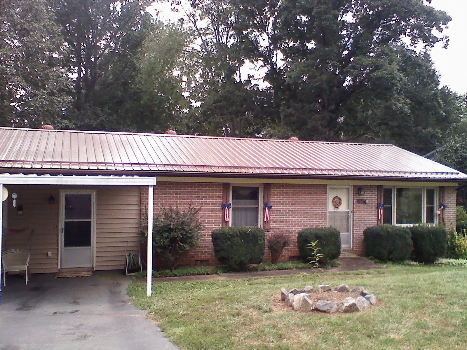 Bronze metal roof and carport on a brick ranch home — Roof Repair work by our crew in West Lebanon